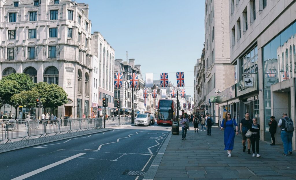 A bustling London street with Union Jack flags and double-decker bus, capturing the city's lively atmosphere.