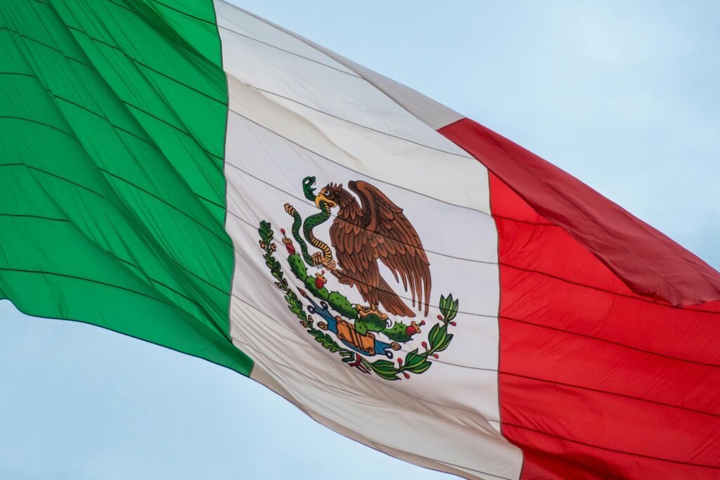 High-resolution image of the Mexican flag waving in the wind, symbolizing national pride and freedom.