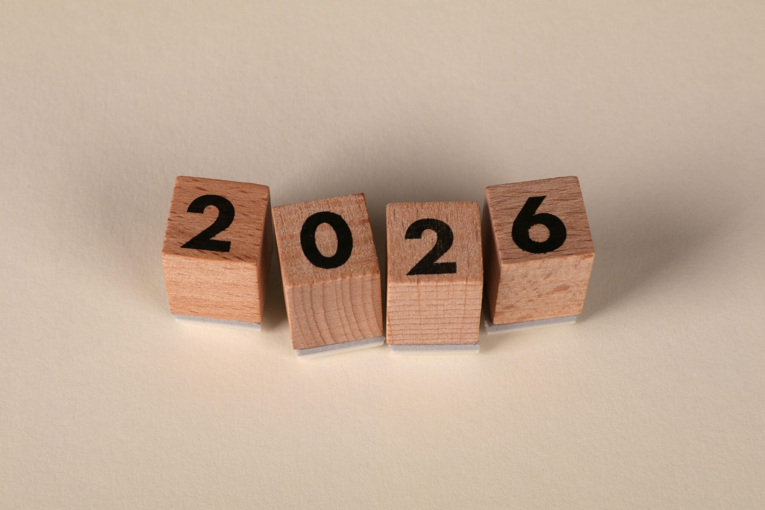 pexels-photo-32417524-32417524 Wooden cubes forming the year 2026 on a neutral background.