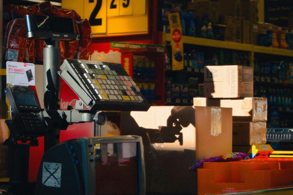 Close-up of a retail checkout counter with boxes and a touchscreen register in a store setting.