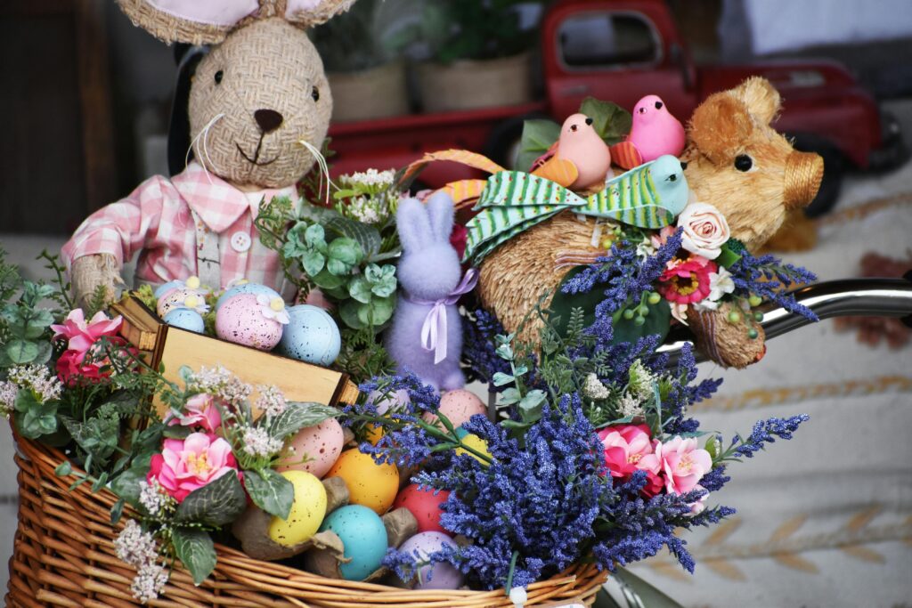 pexels-photo-36825854-36825854 Festive Easter basket filled with decorated eggs, flowers, and plush animals, creating a vibrant holiday display.