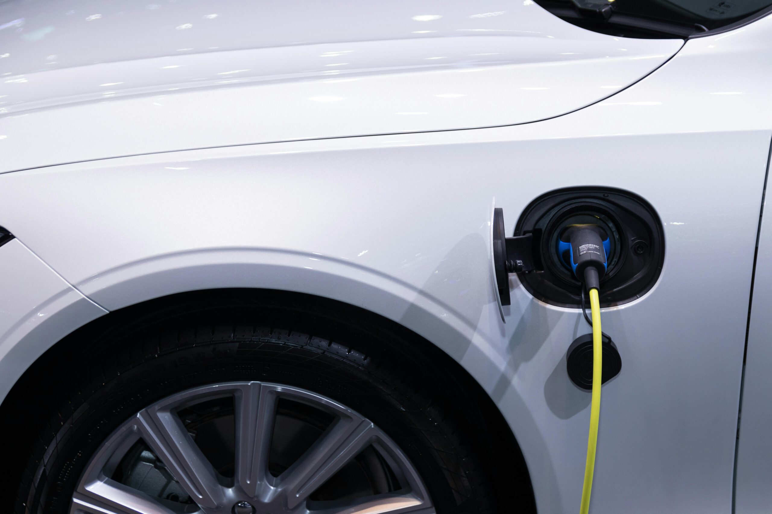 pexels-photo-3846205-3846205 A white electric car is plugged in for charging, close-up view of the charging port.