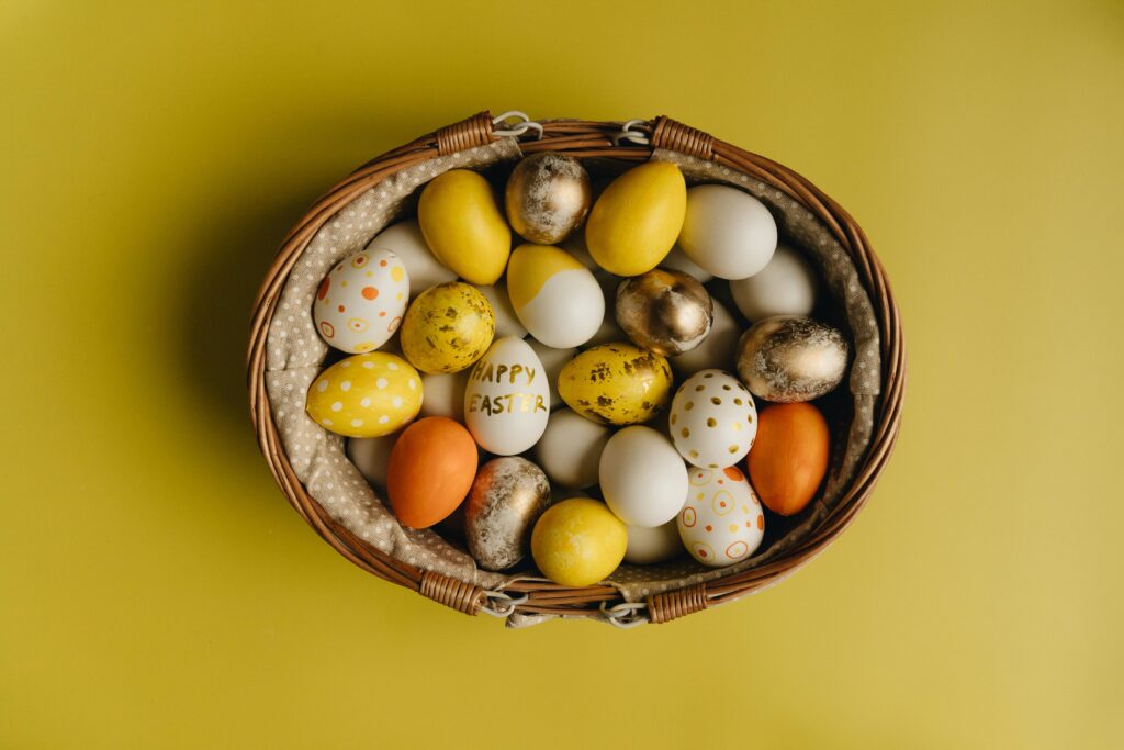 Basket of painted Easter eggs on yellow background. A festive springtime display.