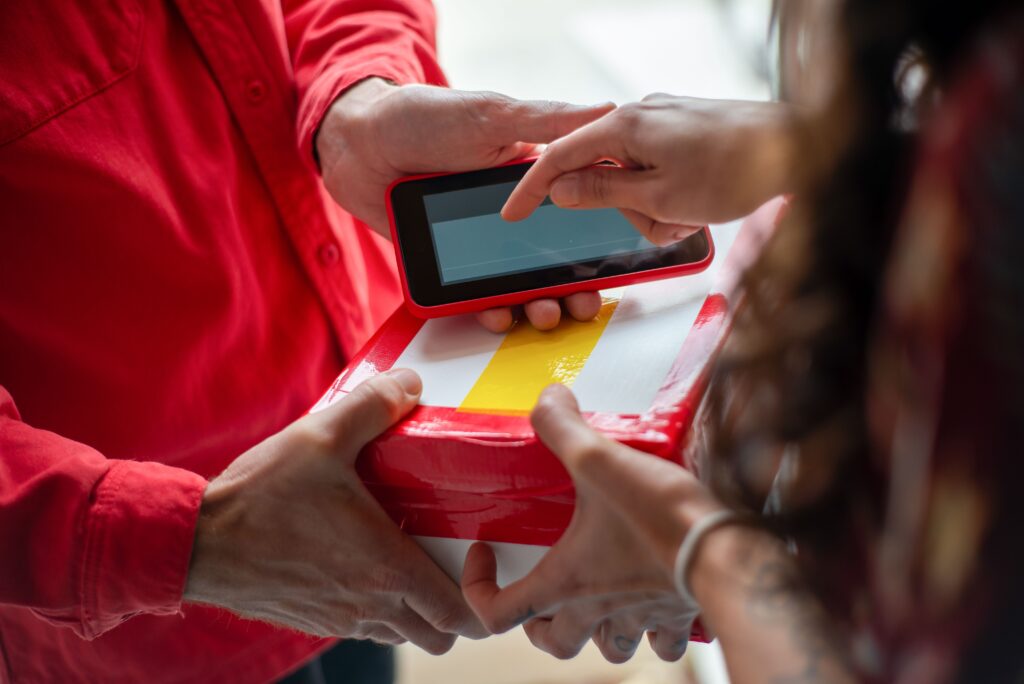 pexels-photo-6721907-6721907-2 Hands exchanging a package with an electronic signature for contactless delivery.