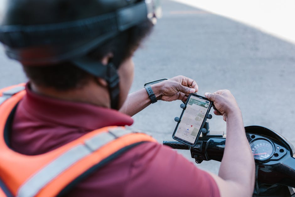 pexels-photo-7362955-7362955 A delivery rider checks directions on a smartphone mounted on a scooter outdoors.