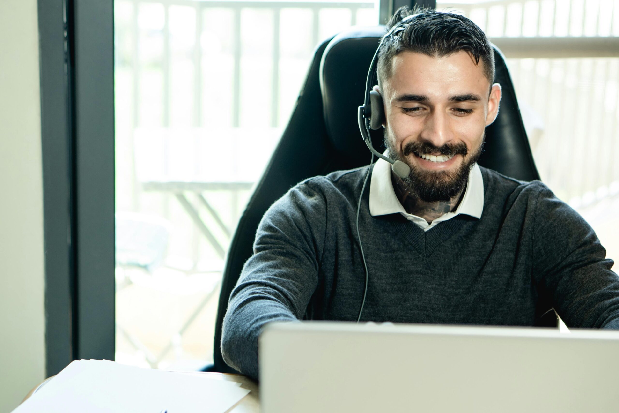 pexels-photo-7504860-7504860 A friendly customer support agent wearing headphones, working in an office environment.