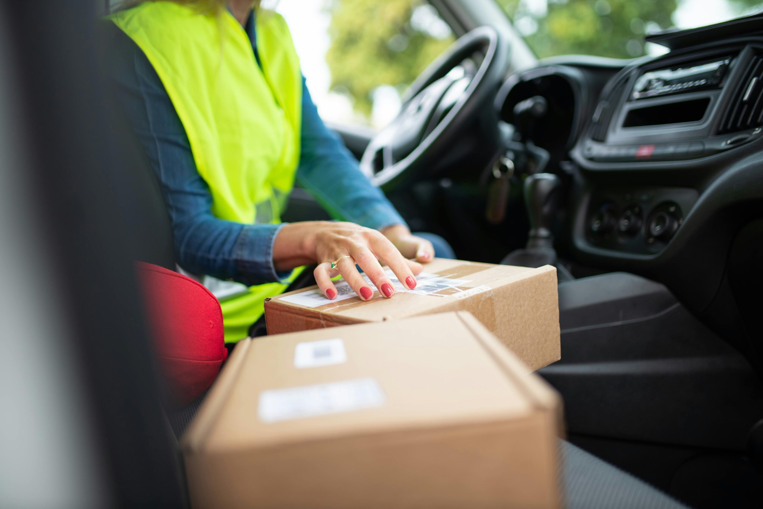 Courier organizing parcels inside a vehicle, highlighting the delivery process. Perfect for logistics themes.