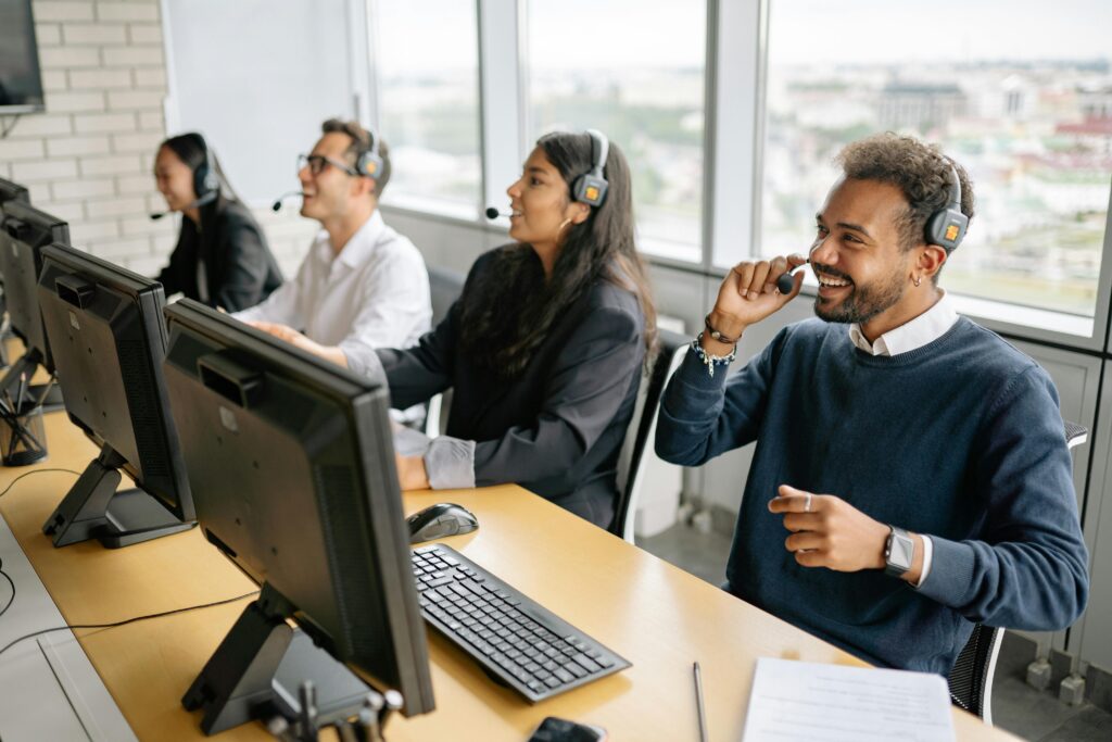 Group of diverse professionals working in a modern call center, engaging with clients through headsets.