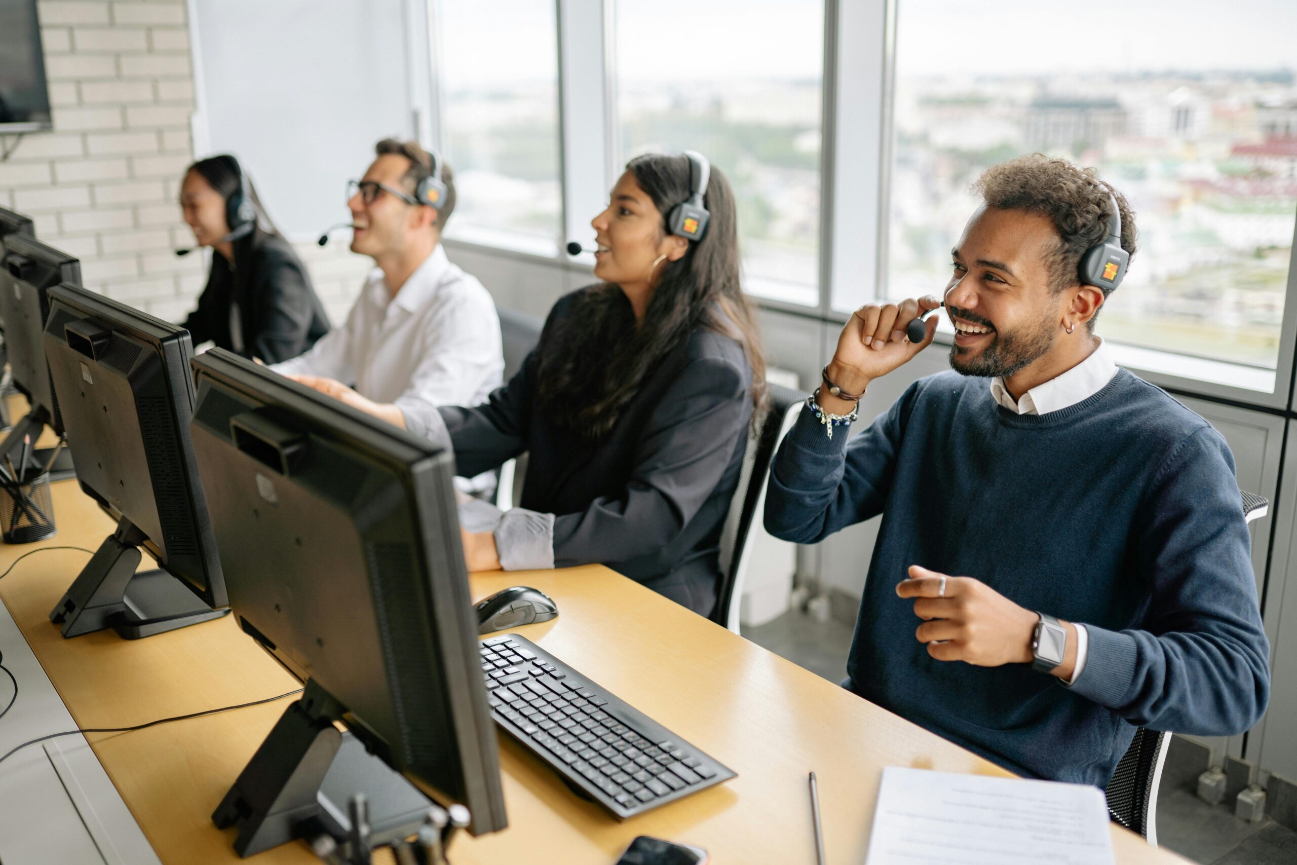 pexels-photo-8867263-8867263 Group of diverse professionals working in a modern call center, engaging with clients through headsets.