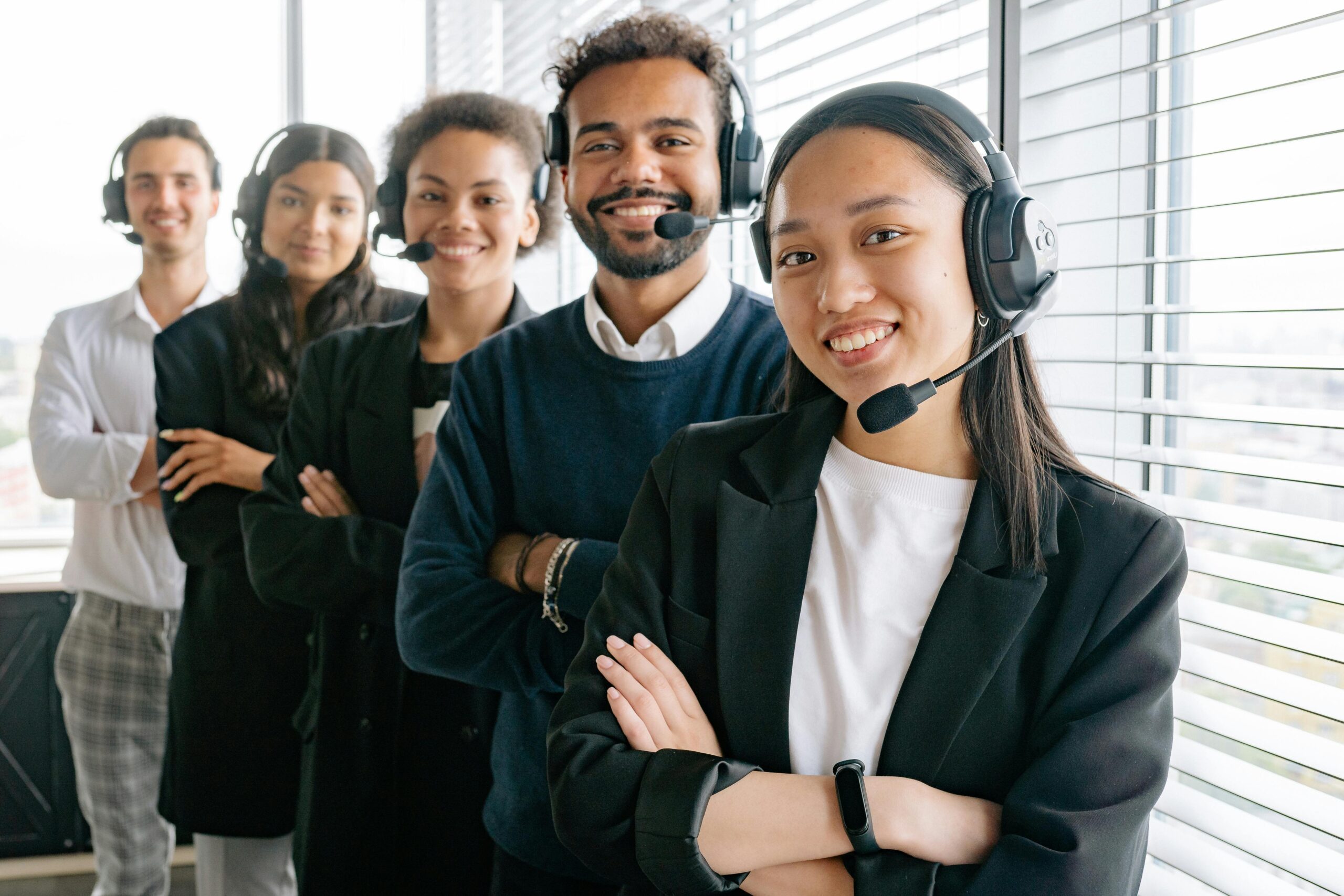 pexels-photo-8867482-8867482 A diverse group of smiling call center agents in an office setting.